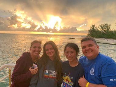 recovering from depression | Lambert-Eaton News | photo of four members of Lori's family, with a body of water and the sun behind them