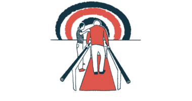 An older man is seen from behind walking between two parallel bars in therapy, as a therapist holds his left arm.