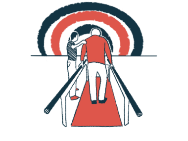 An older man is seen from behind walking between two parallel bars in therapy, as a therapist holds his left arm.